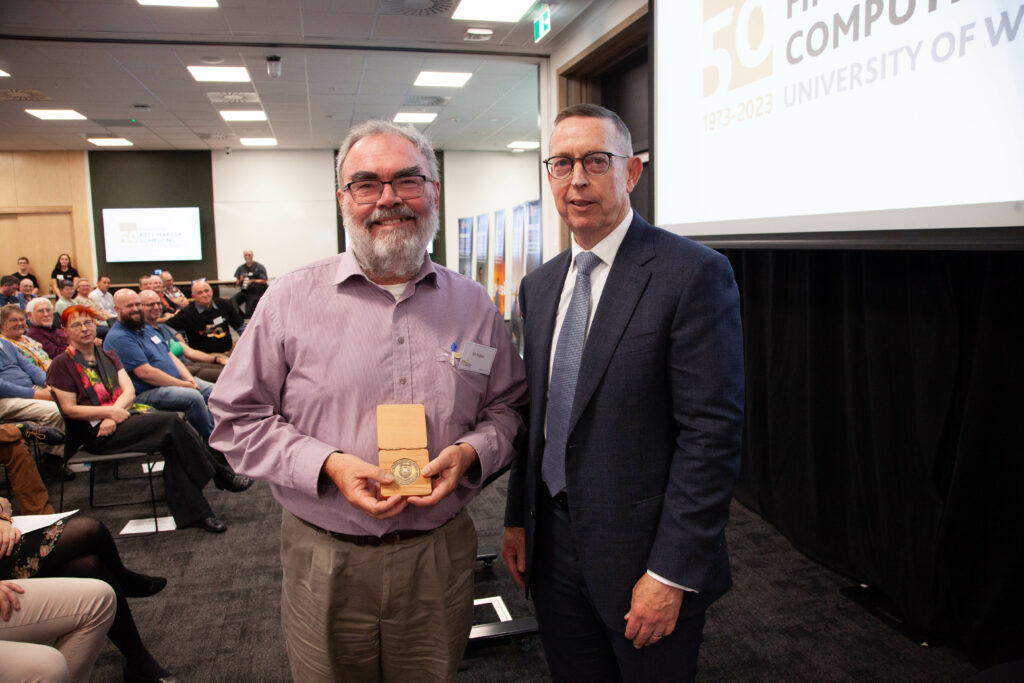 Bill Rogers receives the University of Waikato Medal from the Vice-Chancellor, Professor Neil Quigley.